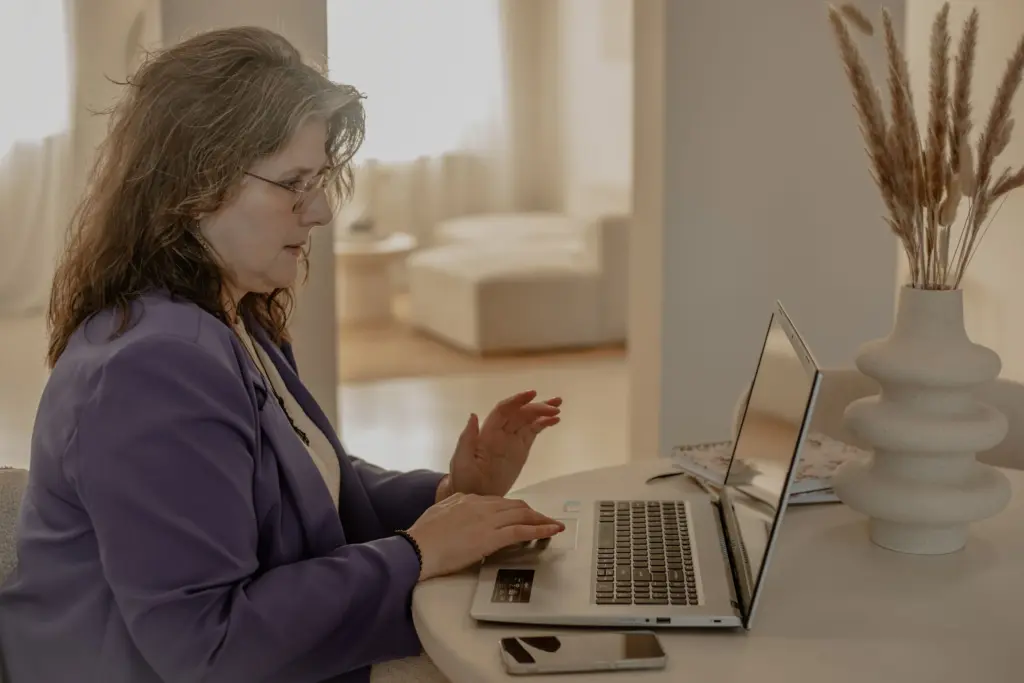 Virtueel assistent Monique Huisman achter computer zijkant perspectief aan het werk
